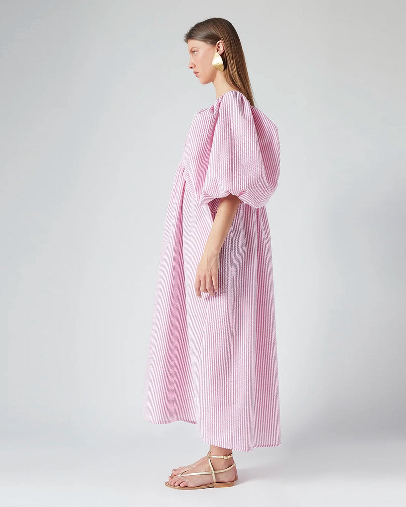 Luźna sukienka maxi Peggy The Label Edition z cienkie paski z krótkimi, bufiastymi rękawami. Posiada kwadratowy dekolt oraz dwie, boczne kieszenie. Jest odcięta pod biustem
