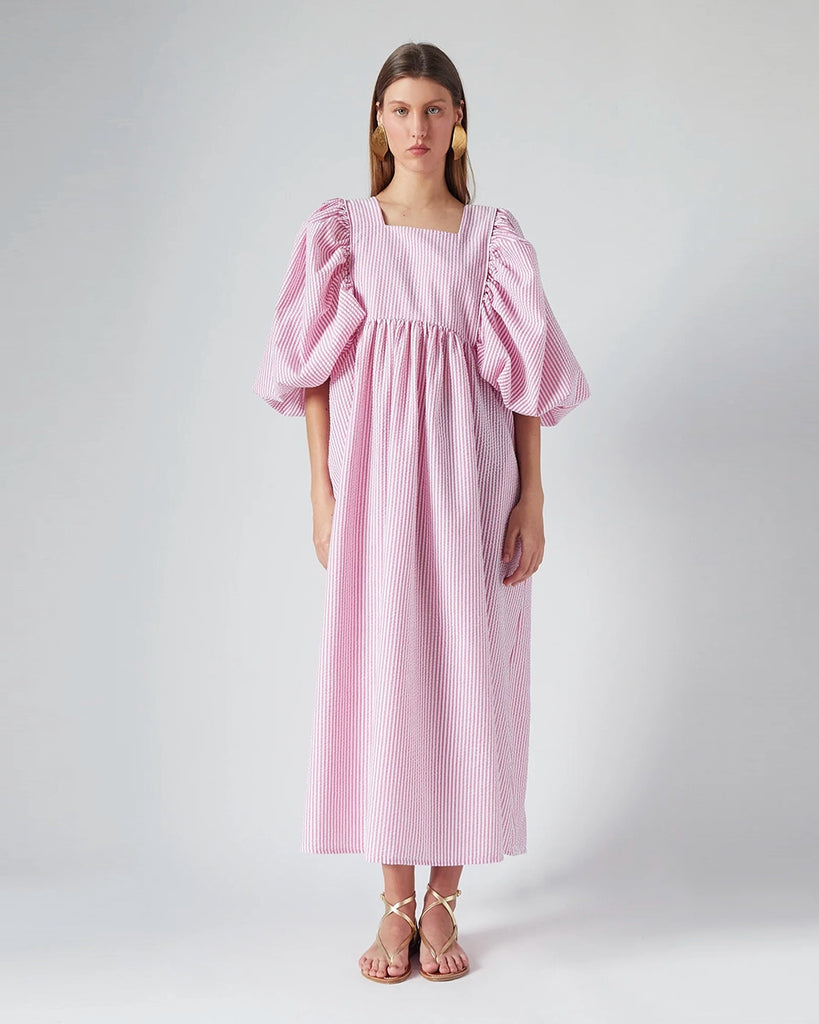 Luźna sukienka maxi Peggy The Label Edition z cienkie paski z krótkimi, bufiastymi rękawami. Posiada kwadratowy dekolt oraz dwie, boczne kieszenie. Jest odcięta pod biustem