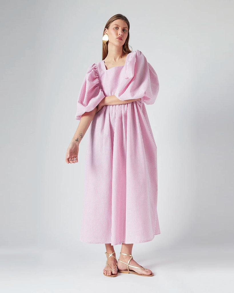 Luźna sukienka maxi Peggy The Label Edition z cienkie paski z krótkimi, bufiastymi rękawami. Posiada kwadratowy dekolt oraz dwie, boczne kieszenie. Jest odcięta pod biustem