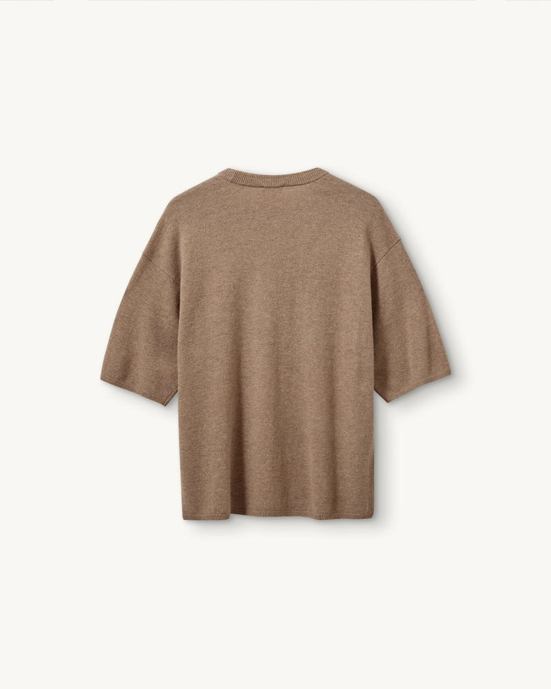 Oversizowy, dzianinowy t-shirt Como The Garment z okrągłym dekoltem i krótkim, luźnym rękawem o długości do łokcia. Posiada prosty krój. Wykonany z bardzo miękkiej, naturalnej dzianiny z wełną i kaszmirem. To minimalistyczna i ponadczasowa bluzka, która sprawdzi się w codziennych stylizacjach. Połącz ją z jeansami, spodniami garniturowymi czy bermudami