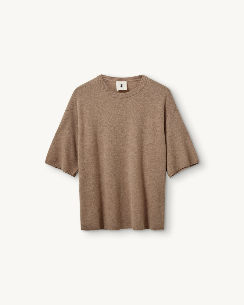 Oversizowy, dzianinowy t-shirt Como The Garment z okrągłym dekoltem i krótkim, luźnym rękawem o długości do łokcia. Posiada prosty krój. Wykonany z bardzo miękkiej, naturalnej dzianiny z wełną i kaszmirem. To minimalistyczna i ponadczasowa bluzka, która sprawdzi się w codziennych stylizacjach. Połącz ją z jeansami, spodniami garniturowymi czy bermudami
