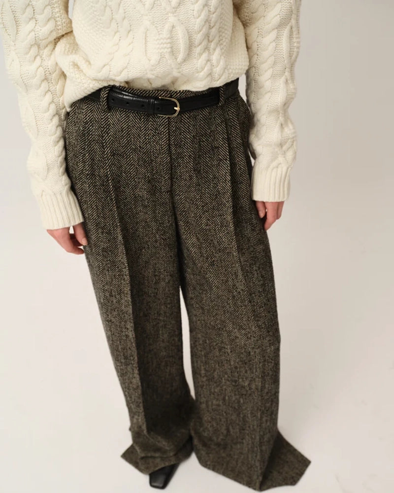 Szerokie, garniturowe spodnie York The Garment z wysokim stanem, zakładkami i długą, prostą nogawką z rozcięciami u dołu. Wykonane z teksturalnej tkaniny z wełną we wzór w jodełkę. Idealne do mokasynów i luźnego swetra lub przylegającego t-shirtu