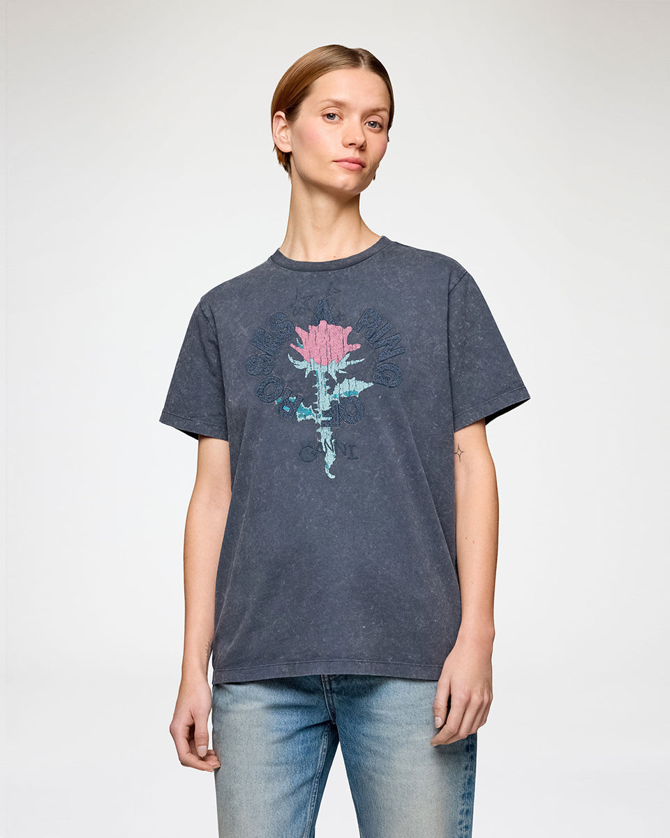 Luźny, bawełniany t-shirt with Rose Phantom GANNI z okrągłym dekoltem i krótkim, szerokim rękawem. Z przodu posiada grafikę róży, haft ,a ring of roses' oraz haft z logo GANNI. Ma niejednolity kolor, z efektem sprania.

-Luźny krój

-100% bawełna&nbsp;

-Zamów t-shirt w swoim standardowym rozmiarze. Jeśli chcesz, żeby był bardziej oversizowy - zamów go w większym rozmiarze.
