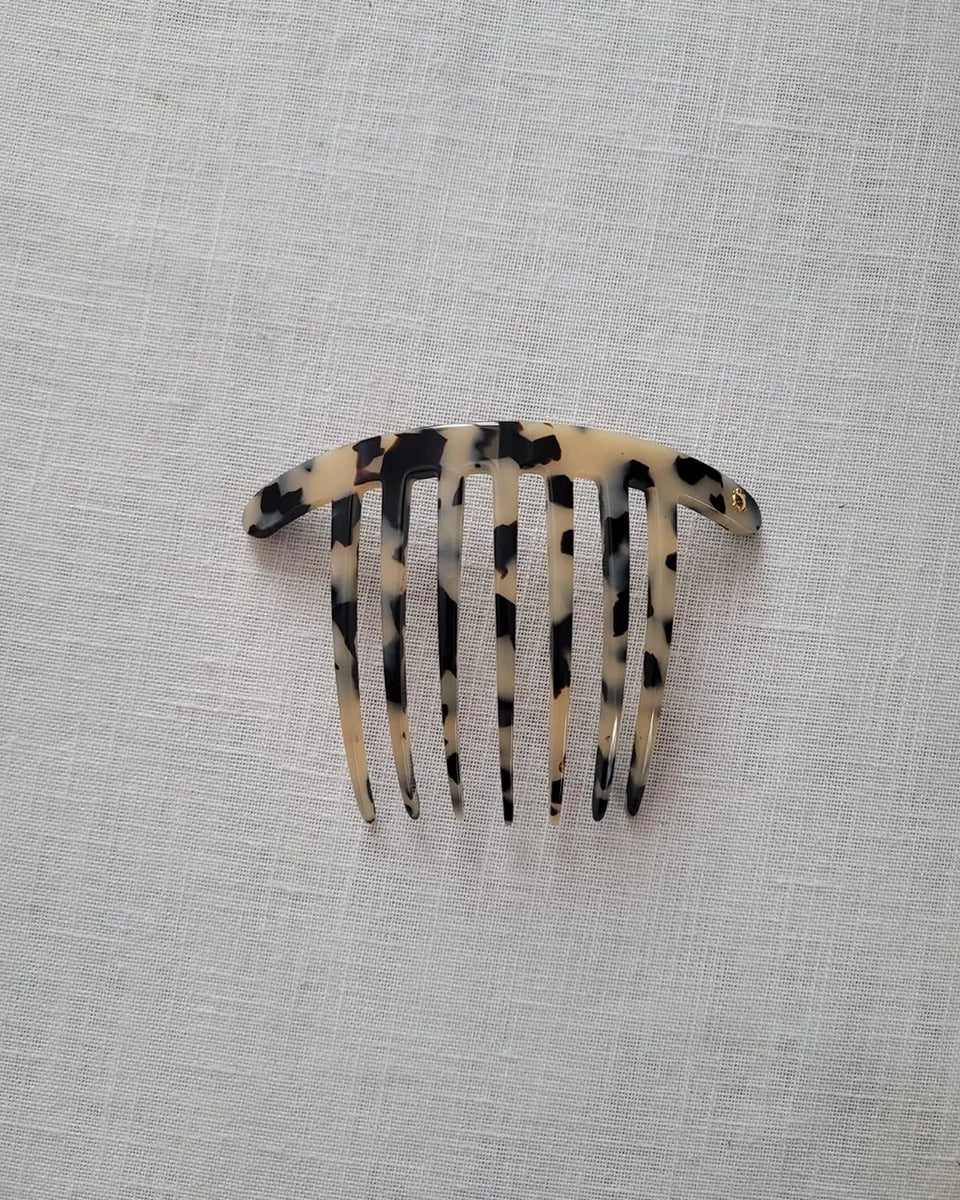 Ręcznie wykonana, minimalistyczna spinka Turtle Story w stylu vintage. Zapinana za pomocą automatycznego zapięcia. Wykonana z włoskiego, biodegradowalnego, nie ropopochodnego octanu celulozy. Dekorowana niewielką, złotą aplikacją o kształcie żółwia będącego znakiem rozpoznawczym marki. 