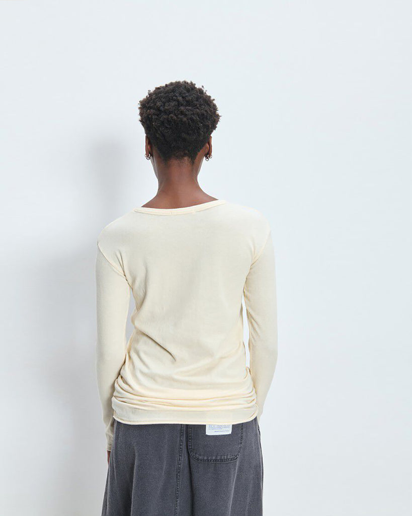 Lekki, dopasowany T-shirt UDA02 Ecru francuskiej marki American Vintage z długim rękawem i okrągłym dekoltem. Wykonany z miękkiej, elastycznej bawełny, dzięki czemu idealnie dopasowuje się do sylwetki. Idealny do codziennych, jak i bardziej formalnych stylizacji.&nbsp;