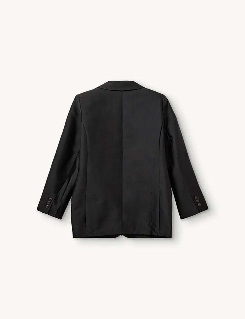 Klasyczna, jednorzędowa marynarka Umami Black o prostym kroju i długości za biodra. Zapinana na dwa guziki. Marynarka ma klapy i trójkątny dekolt. Posiada dwie, przednie kieszenie z klapkami. Wyróżnia się pięknym detalem przypominającym kokardę na kieszeni na piersi.&nbsp;