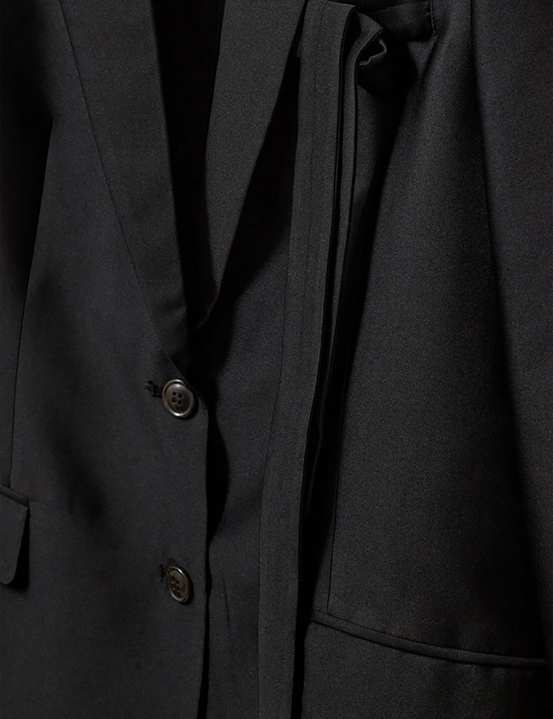 Klasyczna, jednorzędowa marynarka Umami Black o prostym kroju i długości za biodra. Zapinana na dwa guziki. Marynarka ma klapy i trójkątny dekolt. Posiada dwie, przednie kieszenie z klapkami. Wyróżnia się pięknym detalem przypominającym kokardę na kieszeni na piersi.&nbsp;