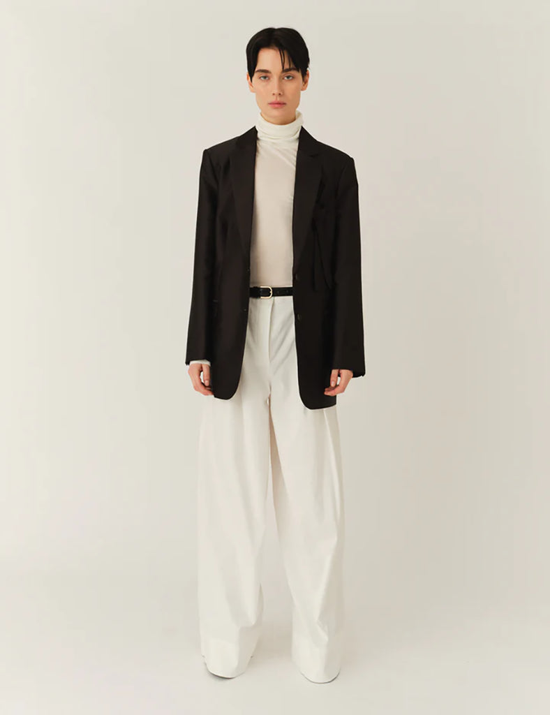 Klasyczna, jednorzędowa marynarka Umami Black o prostym kroju i długości za biodra. Zapinana na dwa guziki. Marynarka ma klapy i trójkątny dekolt. Posiada dwie, przednie kieszenie z klapkami. Wyróżnia się pięknym detalem przypominającym kokardę na kieszeni na piersi.&nbsp;