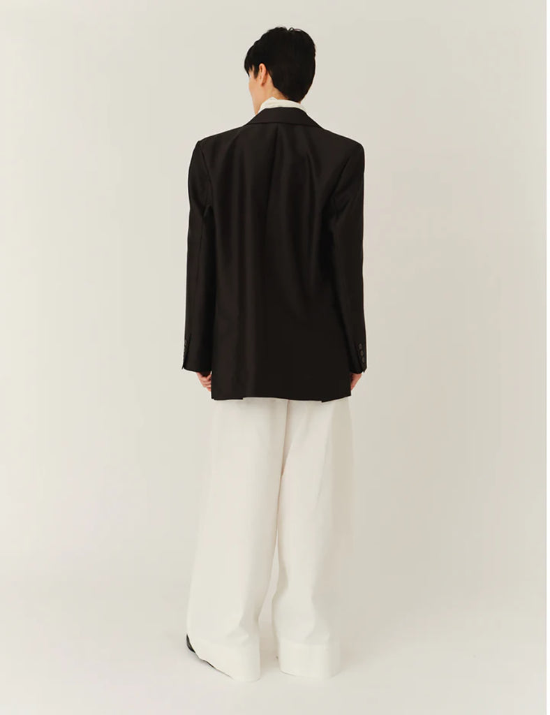 Klasyczna, jednorzędowa marynarka Umami Black o prostym kroju i długości za biodra. Zapinana na dwa guziki. Marynarka ma klapy i trójkątny dekolt. Posiada dwie, przednie kieszenie z klapkami. Wyróżnia się pięknym detalem przypominającym kokardę na kieszeni na piersi.&nbsp;