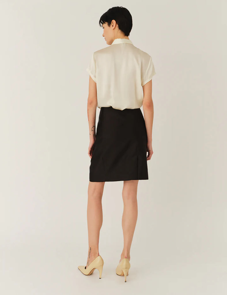 Czarna spódnica Umami Black z wysokim stanem, wykonana z delikatnie połyskującej tkaniny. Wyróżnia się efektownymi detalami z przodu. Zapinana na zamek z tyłu. Połącz ją z marynarką Umami Black, aby stworzyć kompletny, elegancki look.