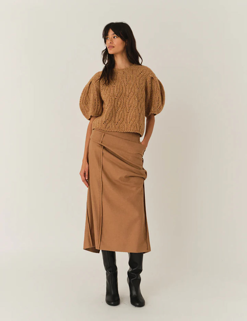 Krótki, dzianinowy sweter Valentina Camel z okrągłym dekoltem i krótkimi, bufiastymi rękawami do łokci, które nadają objętości i romantycznego wyglądu. Sweter ma ozdobny, ażurowy splot o falistym wzorze. Dół oraz mankiety rękawów wykończone są delikatnym ściągaczem. Wykonany z mieszanki wełny i alpaki.