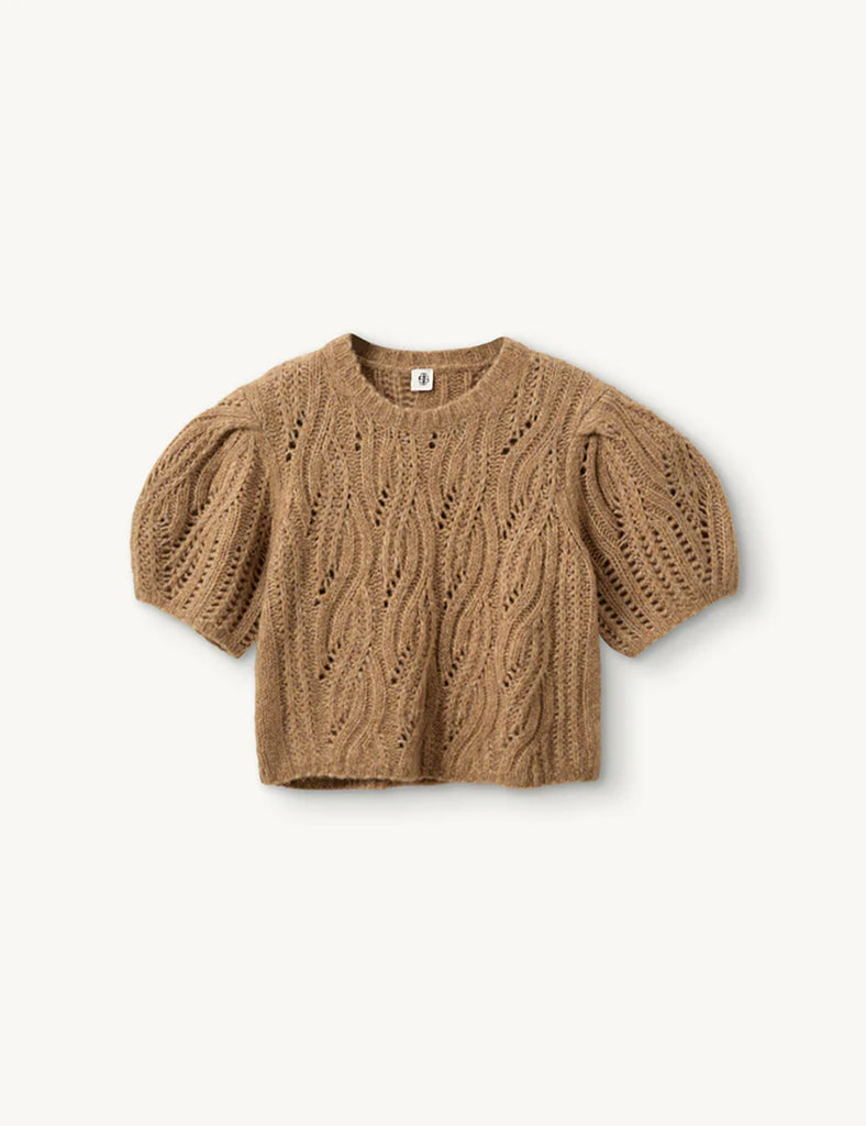 Krótki, dzianinowy sweter Valentina Camel z okrągłym dekoltem i krótkimi, bufiastymi rękawami do łokci, które nadają objętości i romantycznego wyglądu. Sweter ma ozdobny, ażurowy splot o falistym wzorze. Dół oraz mankiety rękawów wykończone są delikatnym ściągaczem. Wykonany z mieszanki wełny i alpaki.