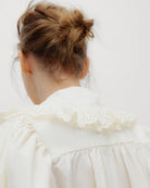 Romantyczna bluzka Vega TNS Whisper White wykonana z miękkiej, przewiewnej bawełny. Wyróżnia się swobodnym krojem oraz eleganckim dekoltem w kształcie litery V, wykończonym delikatnymi falbanami, które dodają całości faktury i ponadczasowej kobiecości. Delikatnie marszczone ramiona oraz obszerne długie rękawy zakończone dopasowanymi mankietami nadają sylwetce wdzięku. Bluzka doskonale sprawdzi się w codziennych stylizacjach, jak i podczas bardziej uroczystych okazji.

-Dekolt w kształcie litery V

-Delikatn