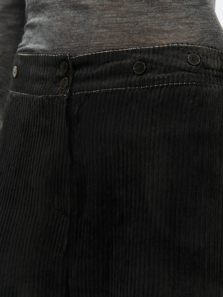 Sztruksowe, luźne spodnie Velvet Rib Carbone ze średnim stanem i szerokimi nogawkami. Posiadają kontrastujące, kremowe przeszycia i pas z ozdobnymi guzikami i gumką z tyłu. Mają jedną kieszeń wpuszczaną z tyłu. Zapinane na guzik i ukryty zamek błyskawiczny.&nbsp;