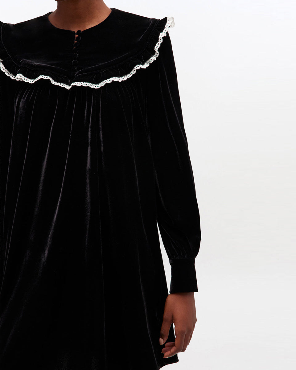 Welurowa, mini sukienka Velvet Black marki GANNI z dużym, zaokrąglonym kołnierzem z kontrastowym, koronkowym obszyciem i długimi, lekko bufiastymi rękawami. Rękawy zakończone są eleganckimi mankietami. Z przodu, na kołnierzu widoczny jest rząd małych, powlekanych materiałem guzików. Sukienka ma swobodny fason, który lekko rozszerza się ku dołowi.&nbsp;

-Zamów sukienkę w swoim standardowym rozmiarze