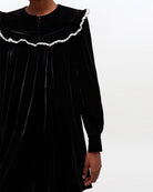 Welurowa, mini sukienka Velvet Black marki GANNI z dużym, zaokrąglonym kołnierzem z kontrastowym, koronkowym obszyciem i długimi, lekko bufiastymi rękawami. Rękawy zakończone są eleganckimi mankietami. Z przodu, na kołnierzu widoczny jest rząd małych, powlekanych materiałem guzików. Sukienka ma swobodny fason, który lekko rozszerza się ku dołowi.&nbsp;

-Zamów sukienkę w swoim standardowym rozmiarze