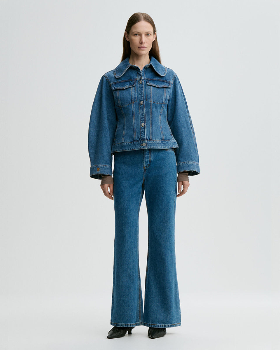 Klasyczna, jeansowa kurtka Villies Denim Blue By Malene Birger z zaokrąglonym kołnierzykiem, szerokimi rękawami i lekko dopasowanym krojem w talii. Długość kurtki sięga do bioder, co dobrze komponuje się ze spodniami z wysokim stanem. Posiada dwie, naszywane kieszenie z klapkami na piersiach. Zapinana na metalowe guziki. Wykonana z bawełny organicznej.&nbsp;

-Klasyczny krój

-Lekko taliowana

-Zamów w swoim standardowym rozmiarze