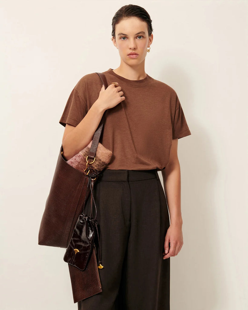 Duża torba typu tote Vita Mia Browny Lezard z nadrukiem imitującym skórę jaszczurki. Zapięcie na zatrzask. Posiada dużą komorę centralną z odpinaną kieszonką, zapinaną na zamek. Z tyłu torby wytłoczone jest logo marki.&nbsp;