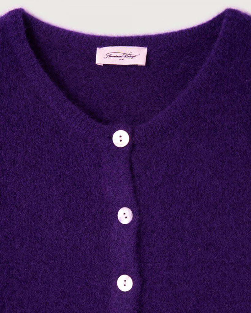 Krótki kardigan Vitow Aubergine marki American Vintage z długim rękawem i okrągłym dekoltem. Zapinany na guziki. U dołu i przy mankietach rękawów wykończony ściągaczami. To ponadczasowy klasyk. Wykonany z miękkiej dzianiny z alpaki i wełny.&nbsp;