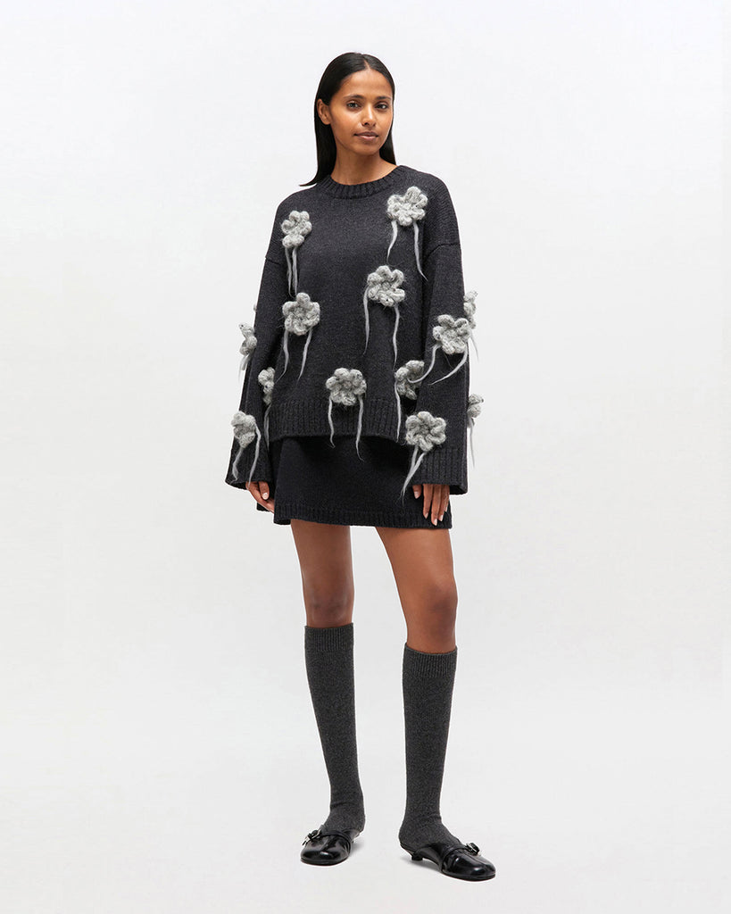 Luźny, ciemnoszary sweter 2624 GANNI Phantom z długimi, szerokimi rękawami i okrągłym dekoltem. Zdobiony pięknymi, haftowanymi kwiatami. Wykończony ściągaczami. Wykonany z dzianiny z wełny. Idealny do spódnicy lub ulubionych jeansów.&nbsp;