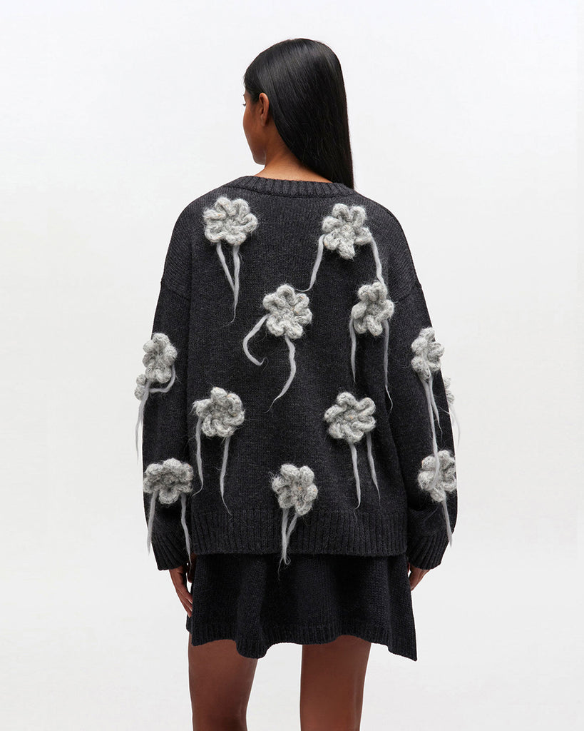 Luźny, ciemnoszary sweter 2624 GANNI Phantom z długimi, szerokimi rękawami i okrągłym dekoltem. Zdobiony pięknymi, haftowanymi kwiatami. Wykończony ściągaczami. Wykonany z dzianiny z wełny. Idealny do spódnicy lub ulubionych jeansów.&nbsp;