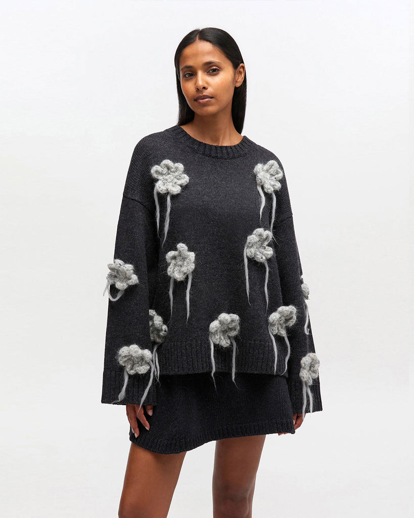 Luźny, ciemnoszary sweter 2624 GANNI Phantom z długimi, szerokimi rękawami i okrągłym dekoltem. Zdobiony pięknymi, haftowanymi kwiatami. Wykończony ściągaczami. Wykonany z dzianiny z wełny. Idealny do spódnicy lub ulubionych jeansów.&nbsp;