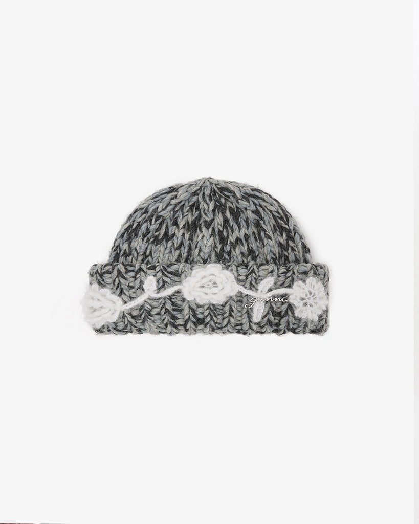 Dzianinowa, wywijana czapka 7308 GANNI Phantom w odcieniach szarości z logo marki. Zdobiona detalami w postaci haftowanych kwiatów. Wykonana z mieszanki wełny i moheru.