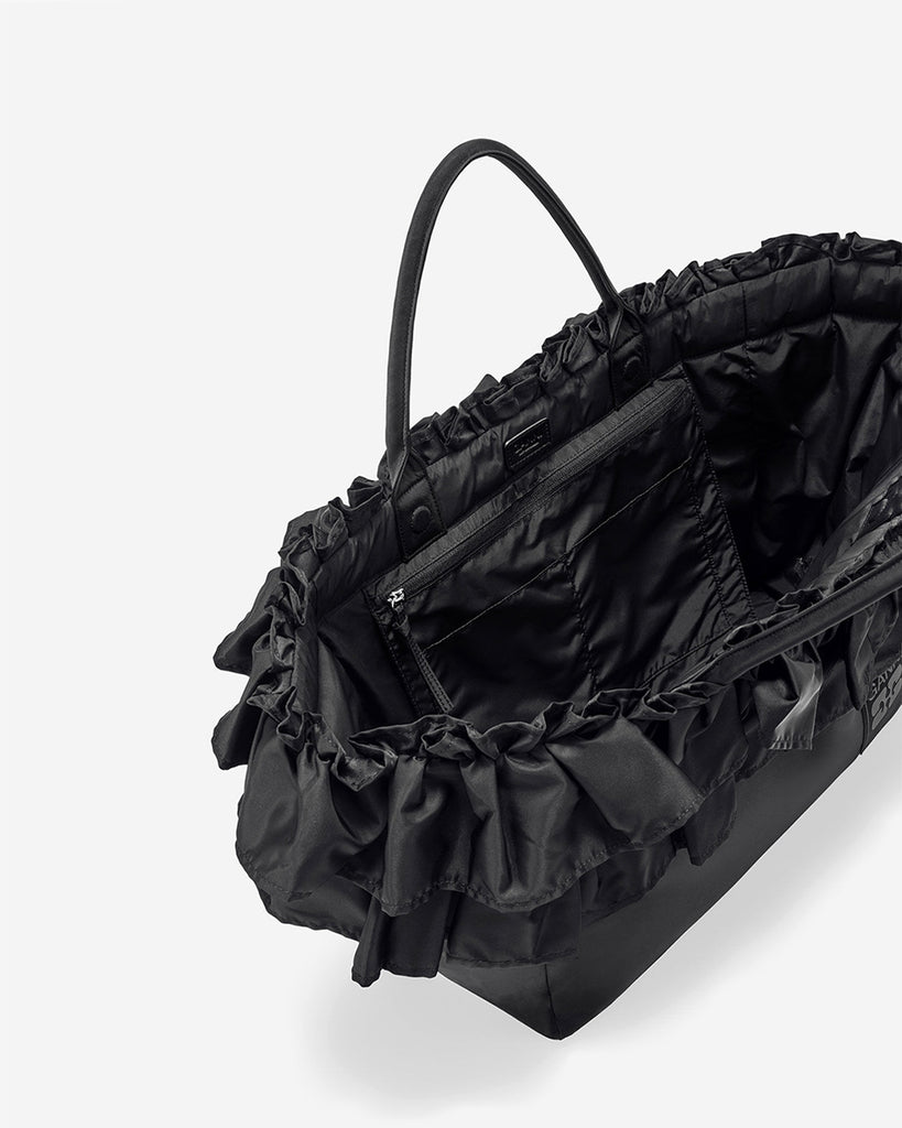 Torba typu tote 7188 XXL Shopper Black marki GANNI z uchwytami. Posiada jedną dużą komorę z wewnętrzną kieszenią zapinaną na zamek. U dołu znajduje się niewielkie logo marki. Wyjątkowości dodaje zdobienie w postaci falbanek. Zaprojektowana, aby pomieścić telefon, portfel, okulary przeciwsłoneczne, klucze, butelkę z wodą, saszetkę, strój sportowy i laptopa.