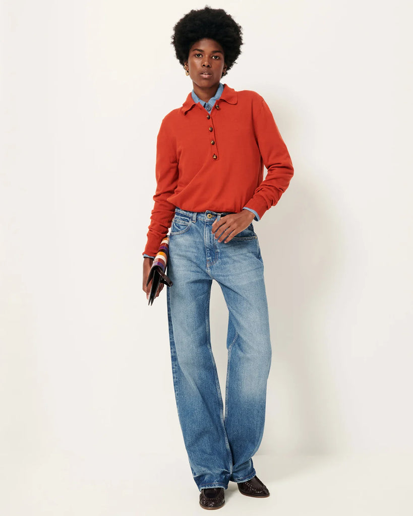 Sweter polo Yanaka Vitamin marki Sessun w kolorze ceglasto-czerwonym z długim rękawem, zakończonym prostym mankietem i kołnierzykiem zapinanym na ozdobne guziki. Wykonany z cienkiej wełny merino. Wykonany z bawełnianej dzianiny.